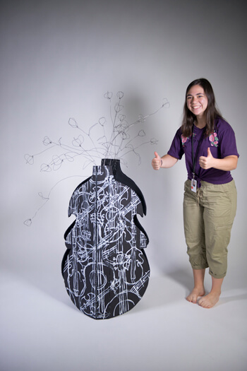 teen showing a thumbs up while getting her art ready for a  photo shoot