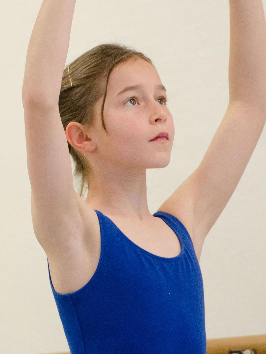 Young female ballet student practicing in class