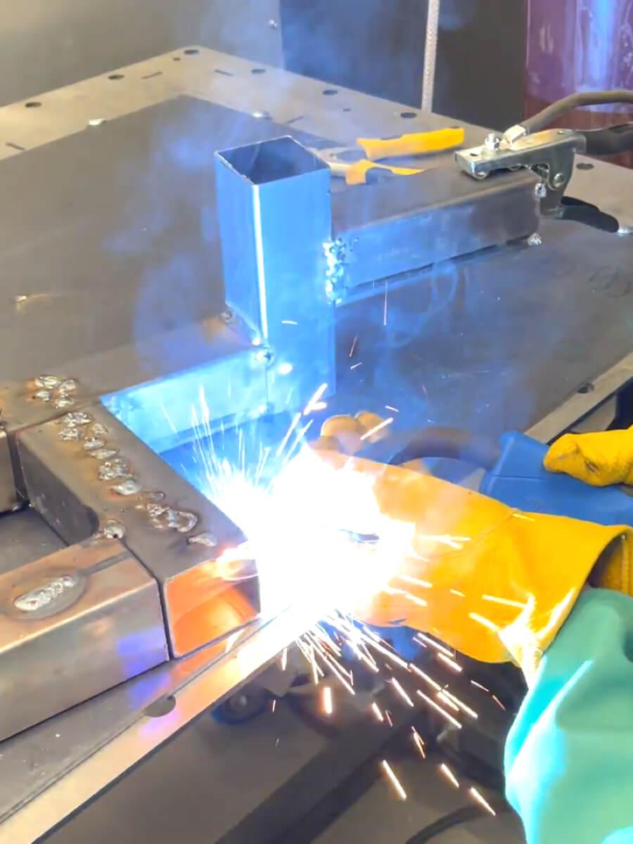 Person welding metal pieces together