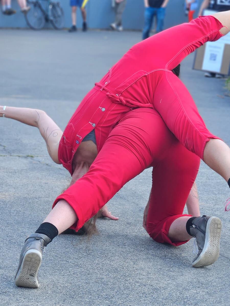Two people dressed all in red doing contact improvisation together