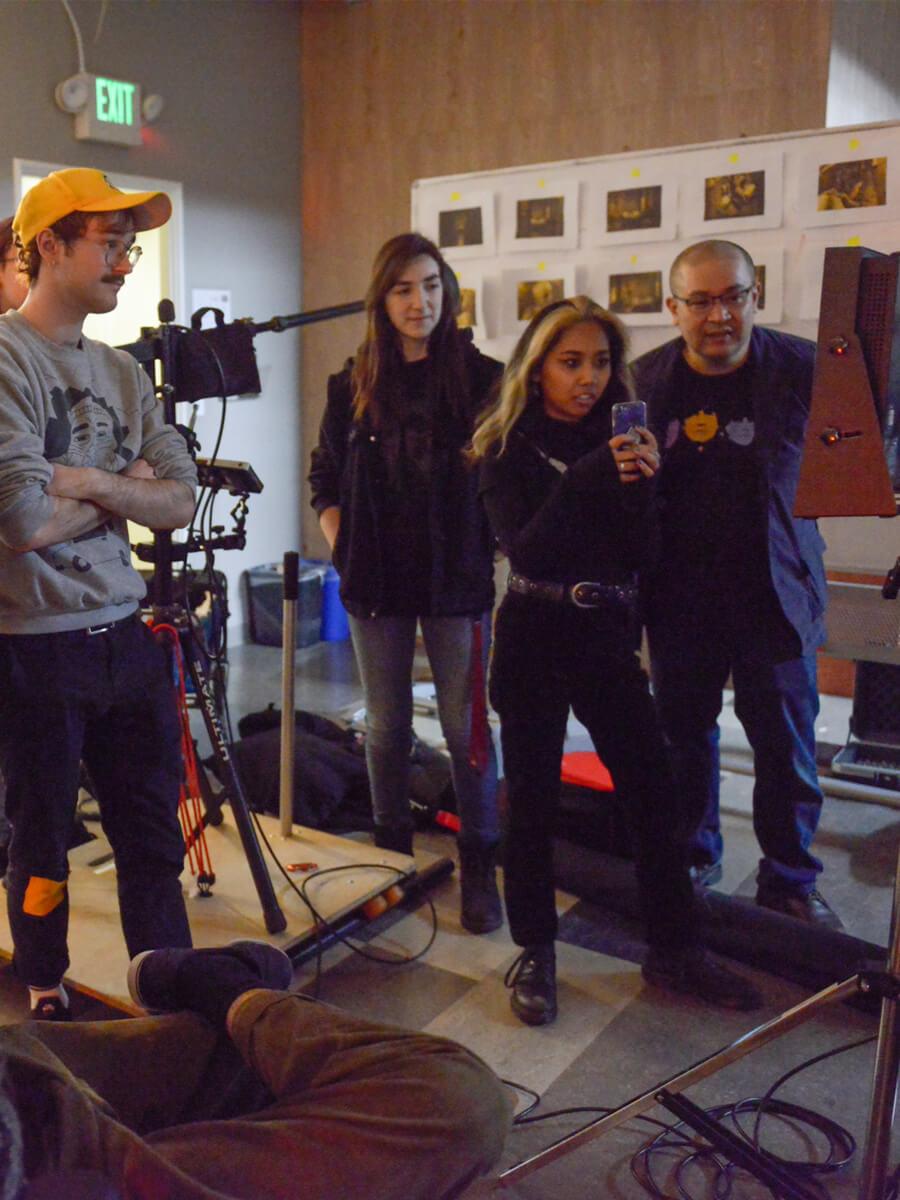film students working on the set with teacher