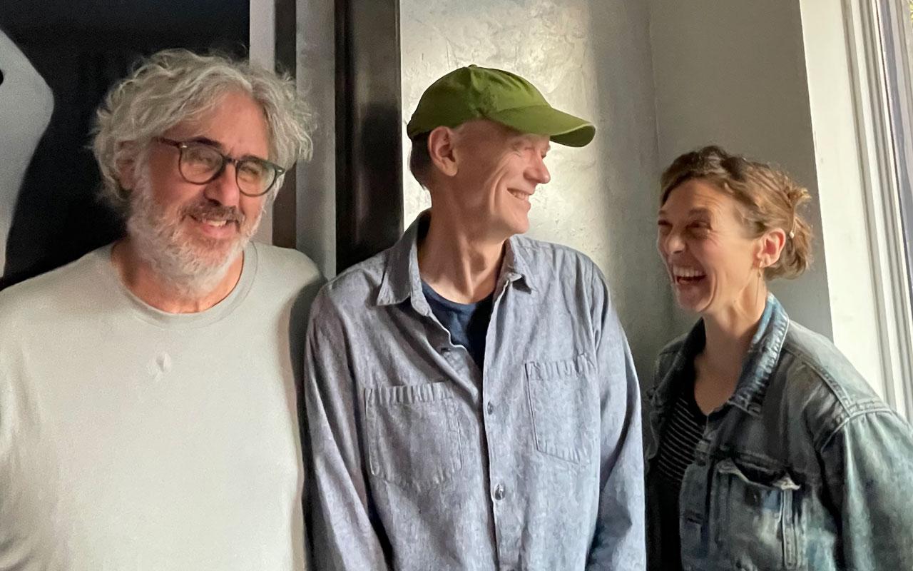 two white males and 1 white woman in plain clothes laughing and talking