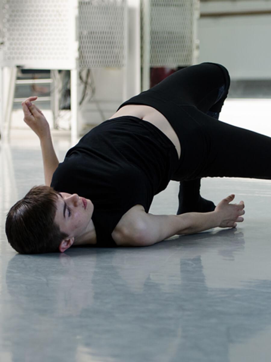 teen improvising a dance move on floor