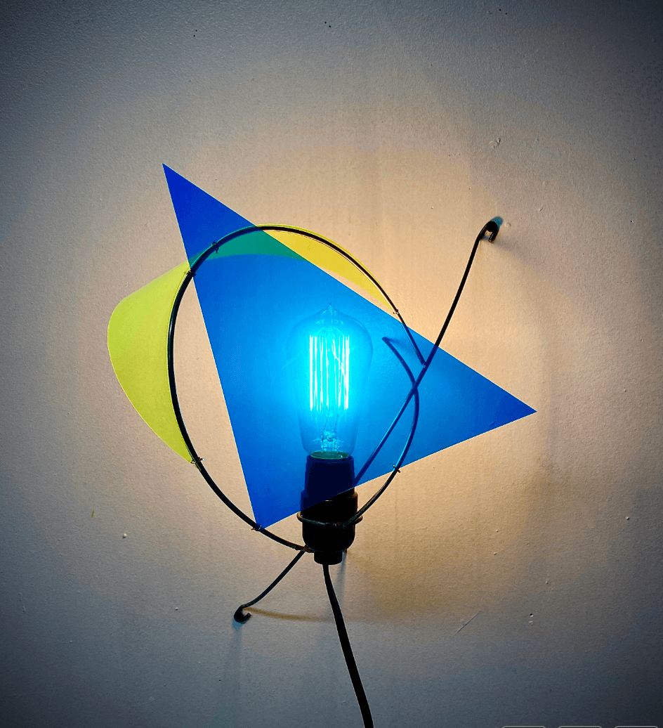 Metal sculpture with rods and a light in the middle with a blue background. 