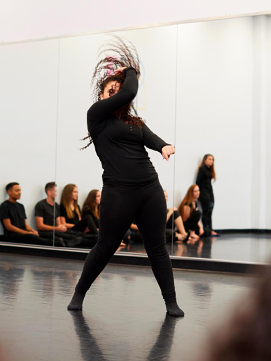 student dancing in all black in classroom