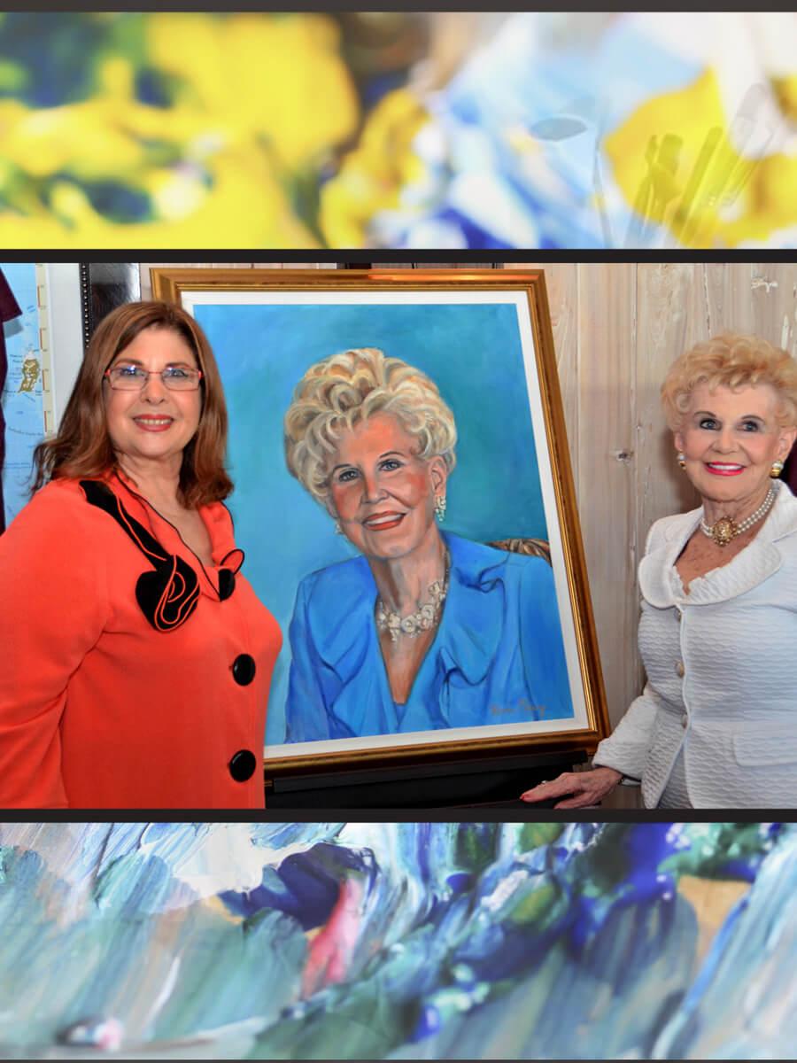 Two women next to a large portrait painting