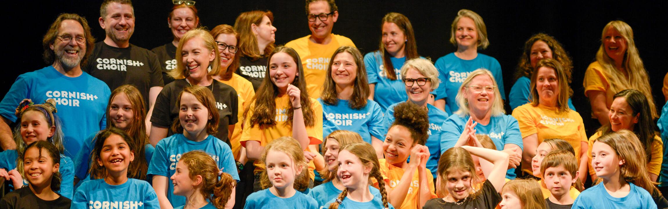 members of Cornish Plus Choir smiling to a person off camera.