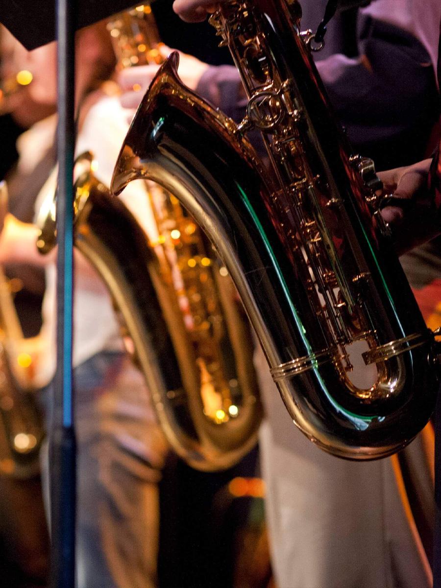 Brass instruments in a line on stage with a music stand.