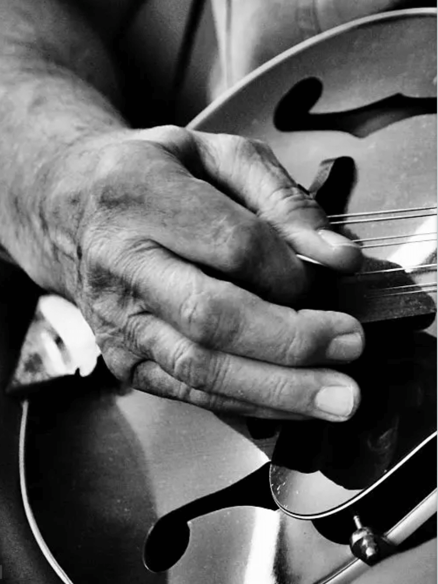 close up images of a persons hand playing the mandolin. 