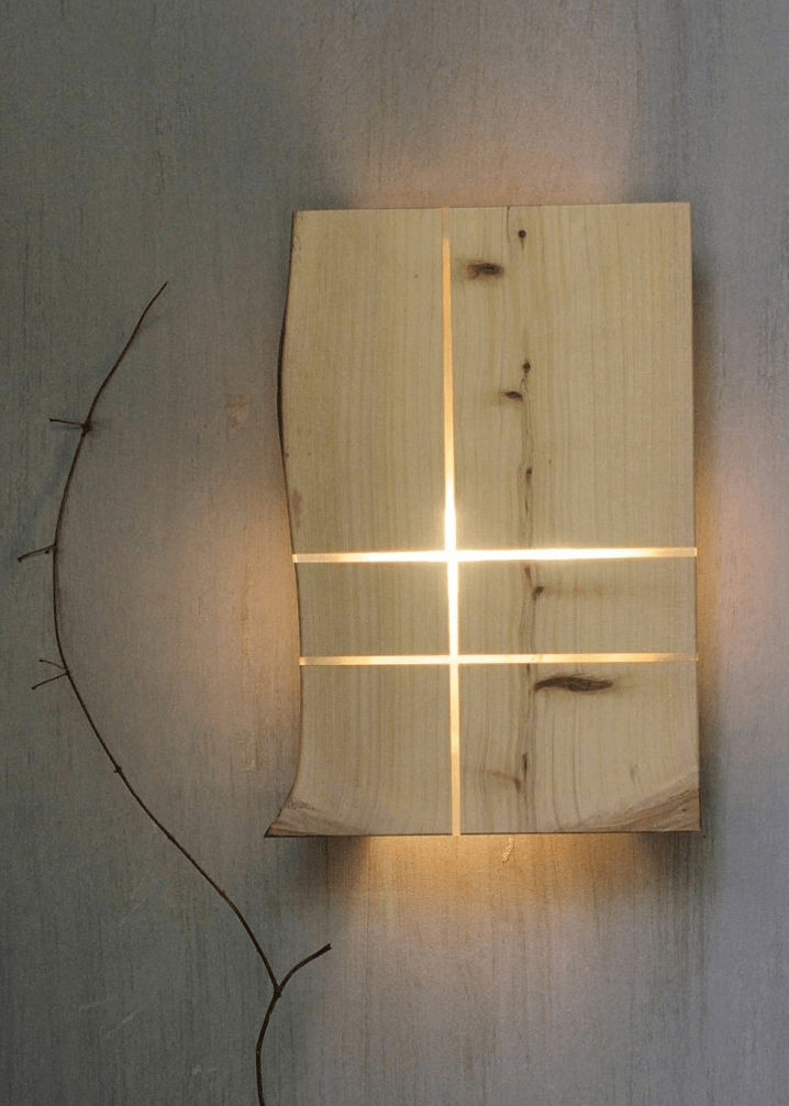 Flat square wooden pine wall lamp with lite up slits of light. 