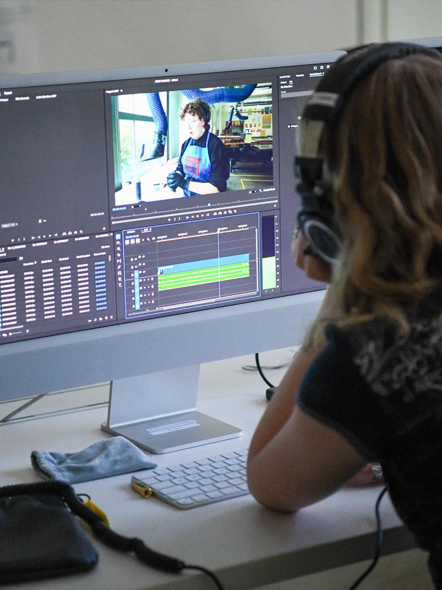 student working on a computer editing film