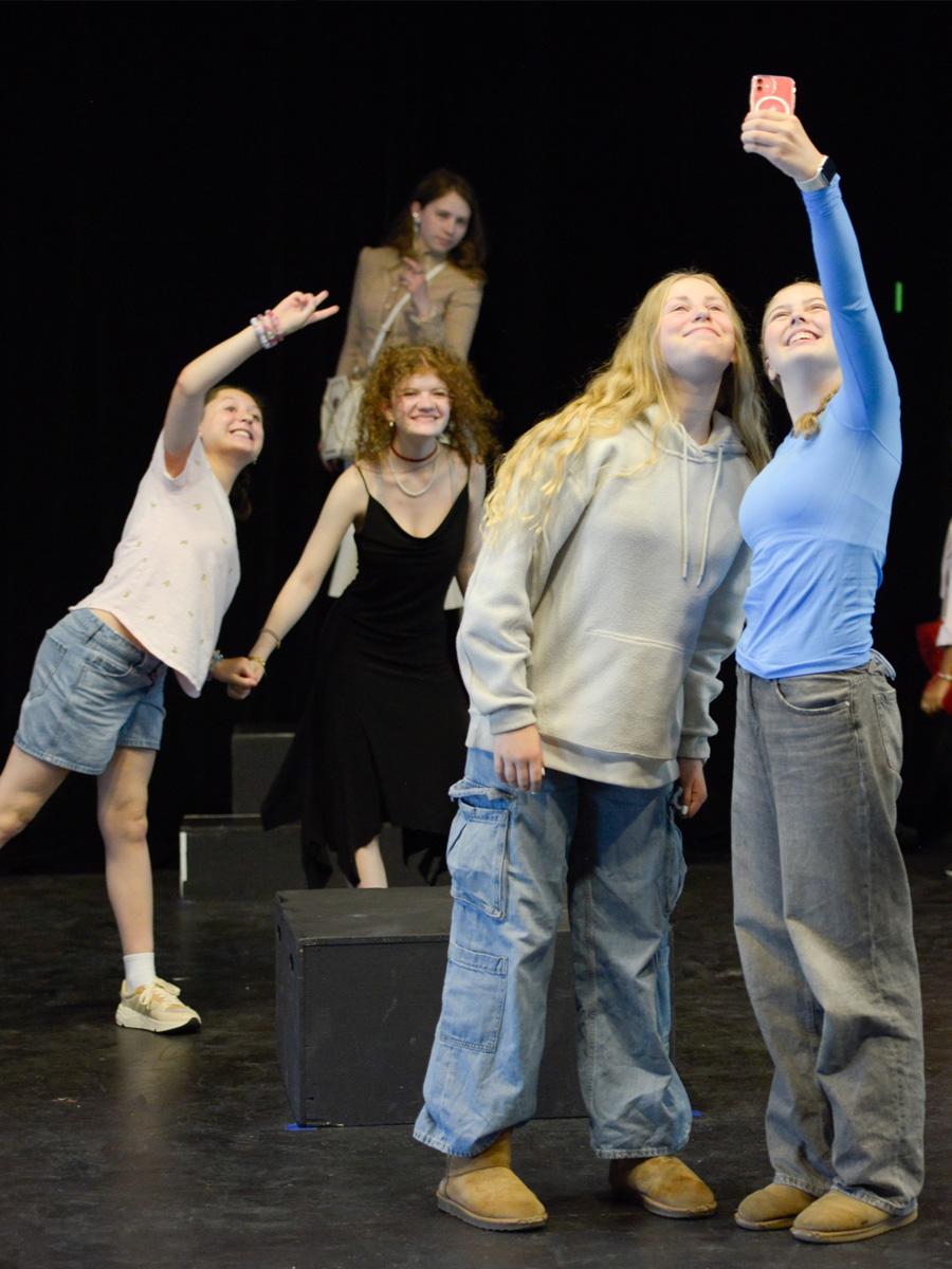 Students on stage in costume for the Musical & Theater performance all in costume. 