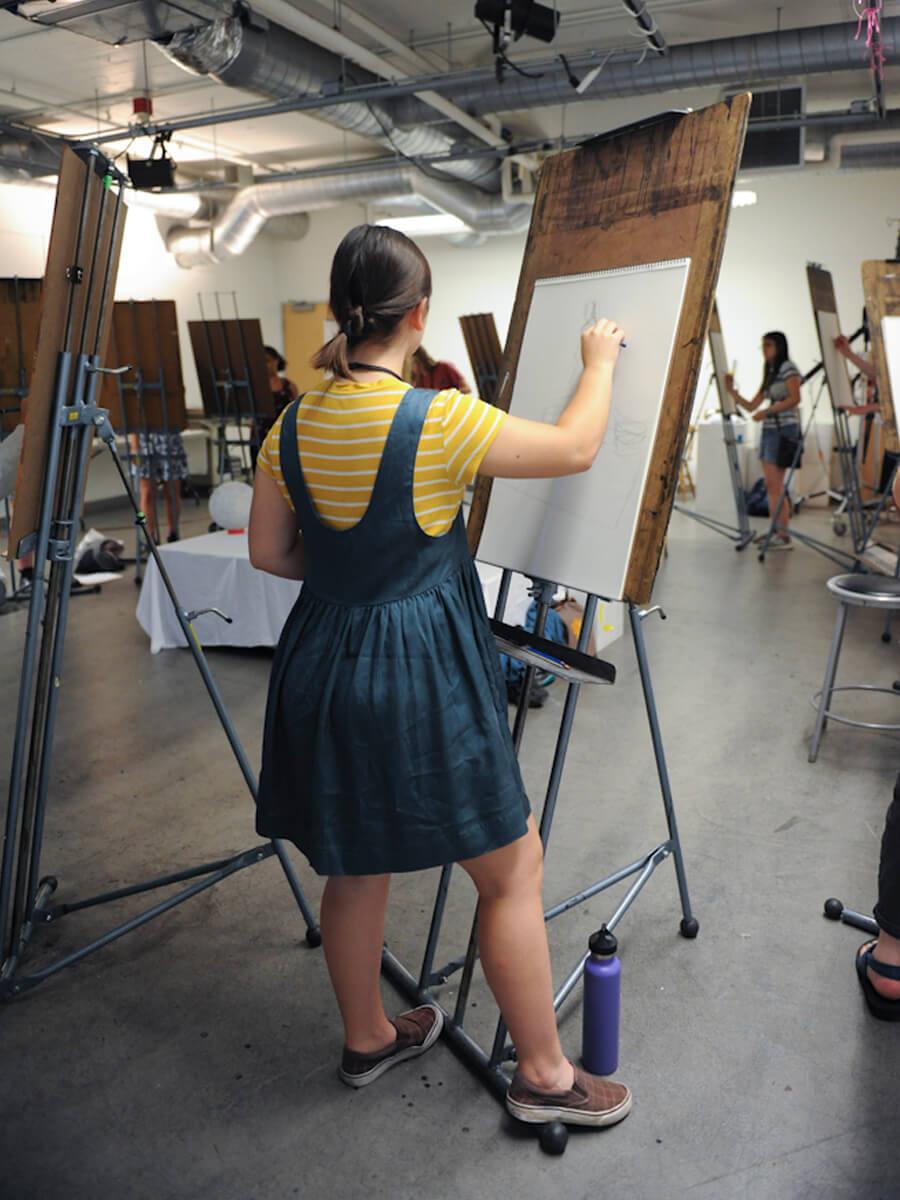 female teenager drawing in a life drawing class