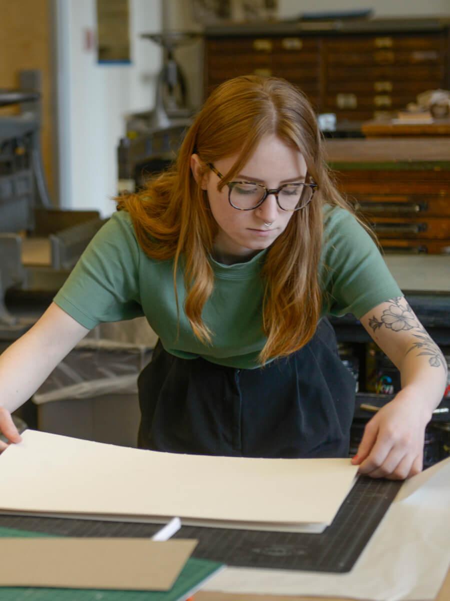 woman working with paper in print studio