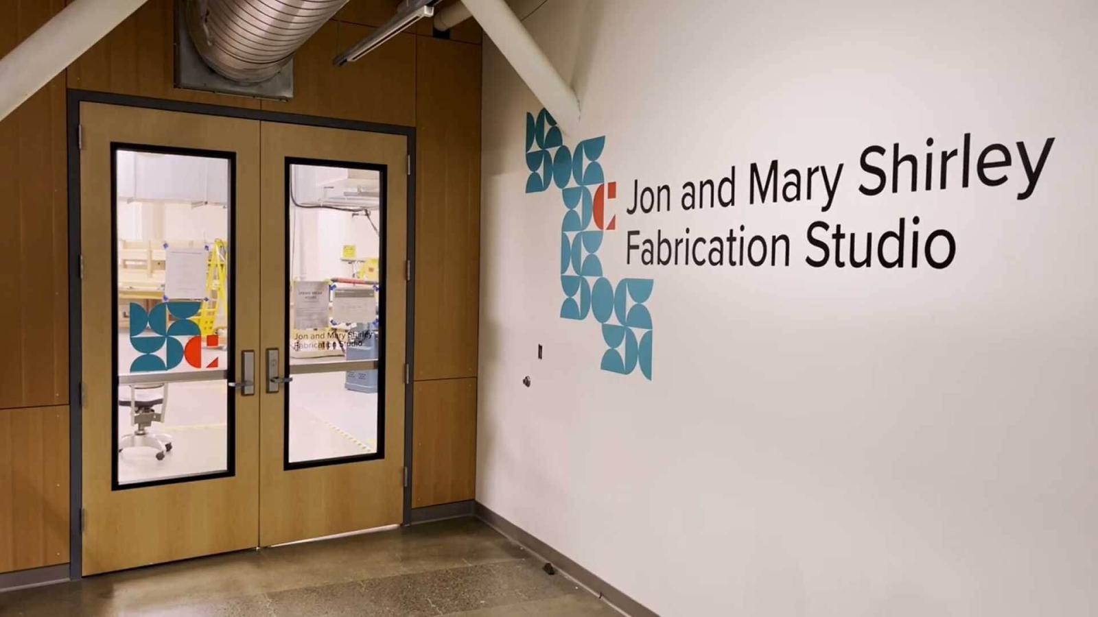 outside of fabrication studio, doors and wall text" jon and shirley fabrication studio