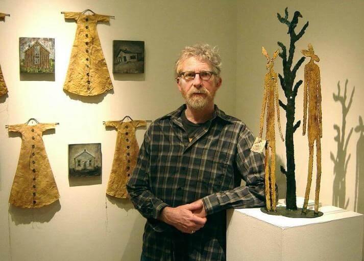 Larry Calkins standing in his gallery