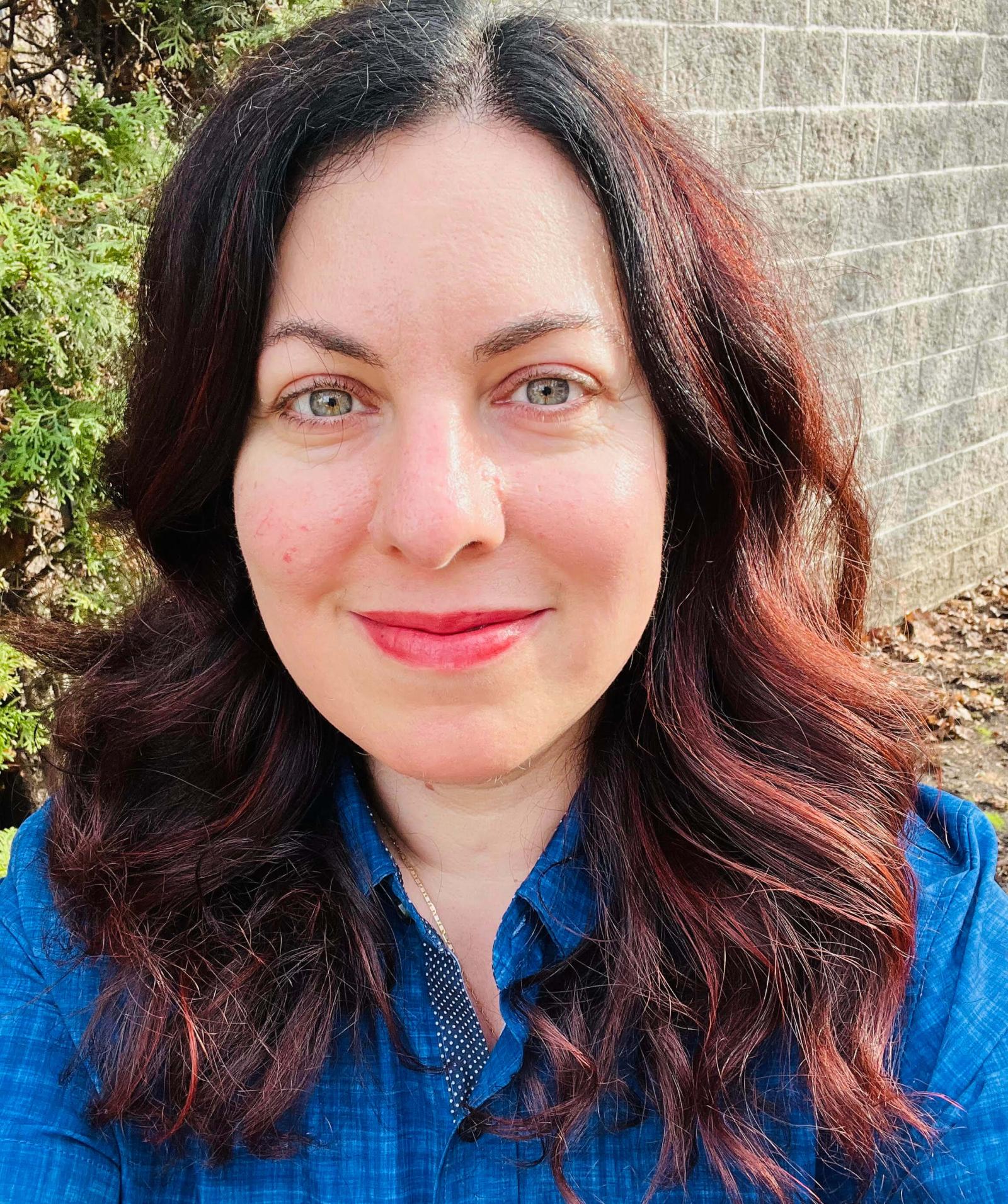 Samar Abulhassan in a blue shirt with long brown hair.