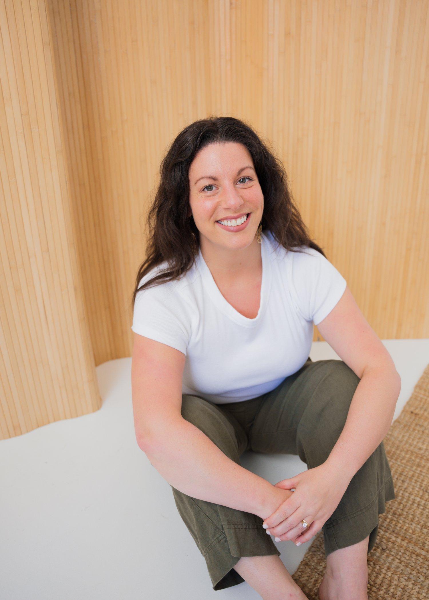 Jenna Spinei in a white t shirt and brown pants and brown hair. 