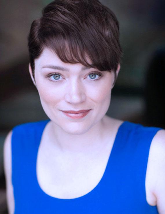 Claire Marx in blue tank top with short brown hair