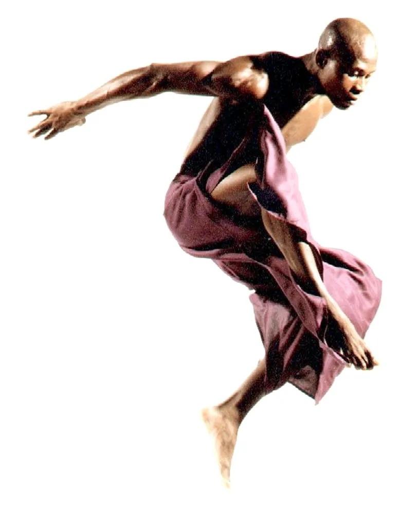 Etienne Capko dancing in the air with baggy red pants