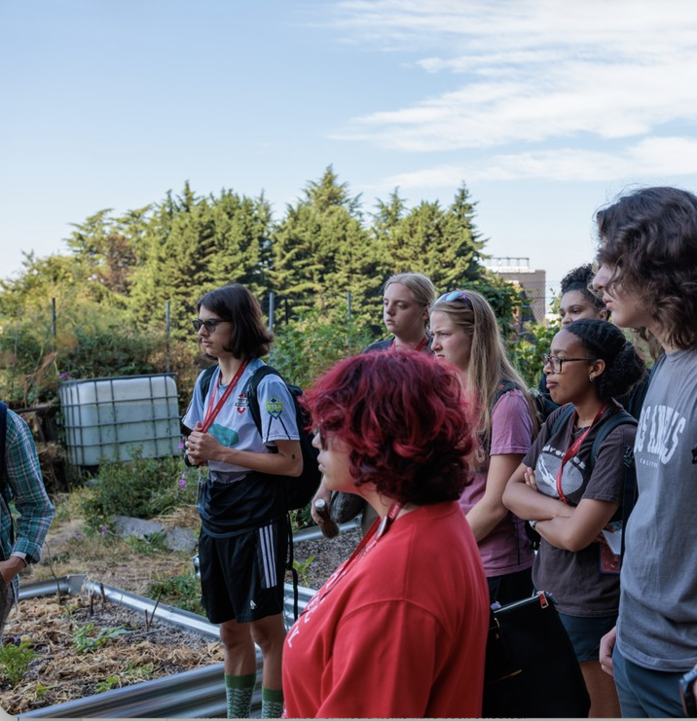 Students on a garden posing for a group photo in colorful work clothes